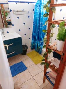 baño con lavabo y cortina de ducha azul en Chez Liliane en Bouillante