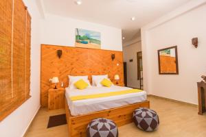 una camera da letto con un letto grande con testiera in legno di Shine Wave Turtle Beach a Tangalle