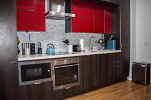 a kitchen with red cabinets and a counter top at Downtown High-rise Condo- CN Tower View in Toronto
