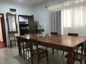 a dining room with a wooden table and chairs at Eco Willow - Kathaluwa in Atadahewatugoda