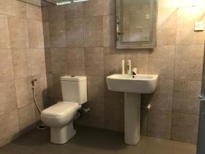 a bathroom with a toilet and a sink at Eco Willow - Kathaluwa in Atadahewatugoda