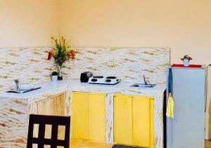 a kitchen with a counter and a yellow refrigerator at RedDoorz @ Thomasville Inland Resort Brgy. 2 in Hinoba-an