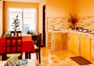 un soggiorno con tavolo e cucina di RedDoorz @ Thomasville Inland Resort Brgy. 2 a Hinoba-an