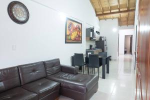 a living room with a leather couch and a dining room at El EmAnJe 1 in Jardin