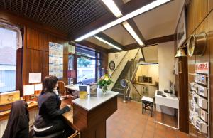 a woman sitting at a counter in a coffee shop at Hotel Hansahof Bremen in Bremen