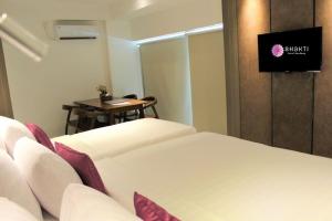 a hotel room with a bed and a small table at Shakti Hotel Bandung in Bandung