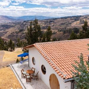 a house with a table and chairs and a view at Las Casitas Quinua in Carsala