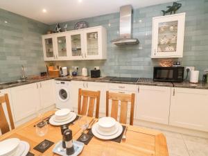 a kitchen with a table with chairs and a microwave at Copper Hill House in Hayle