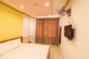 a small bedroom with a bed and a television at 26 Topaz Hotel in Vung Tau