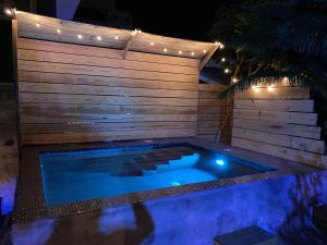 a swimming pool with lights on a wooden wall at OTRO Curaçao - Urban Oasis in Otrobanda in Willemstad