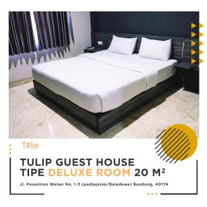 a bed in a hotel room with a white mattress at Tulip Guest House in Bandung