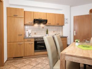 a kitchen with wooden cabinets and a wooden table at Haus Seeblick Steuerbord in Insel Poel