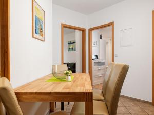 a dining room with a wooden table and chairs at Haus Seeblick Steuerbord in Insel Poel