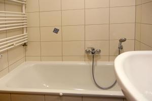 a bath tub with a shower head next to a sink at Haus Seeblick Steuerbord in Insel Poel