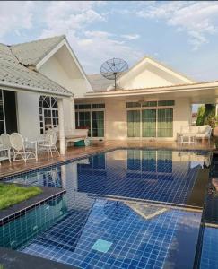 a swimming pool in front of a house at Mountain View Pool Villa in Nakhon Nayok