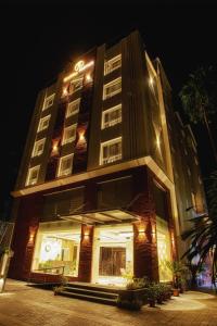 a tall building with lights on it at night at Sunhill Portico in Siliguri