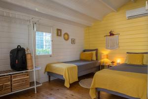 a bedroom with two beds and yellow walls at OTRO Curaçao - Urban Oasis in Otrobanda in Willemstad