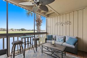 a screened in porch with a couch and a table at Seascape Lakefront Villas 232 in Destin