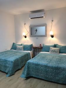 Zimmer mit 2 Betten und einem Spiegel in der Unterkunft Garden Suites Comalcalco in Comalcalco