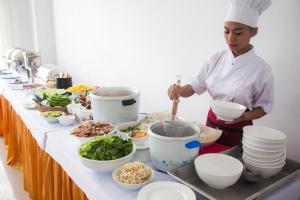 a chef preparing food on a table in a kitchen at Douangchan Plaza Hotel in Vientiane
