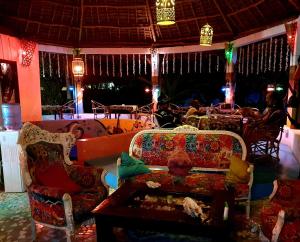 a living room with a couch and a table and chairs at Fontaine Garden Village in Bwejuu