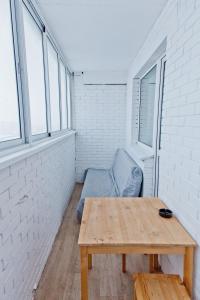 イジェフスクにあるApartments Severny, 54-8の木製テーブルと窓が備わる小さな客室です。