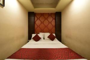 a bedroom with a bed with a red headboard at Shastri Paradise opst to KSRTC Bus Stand in Mysore