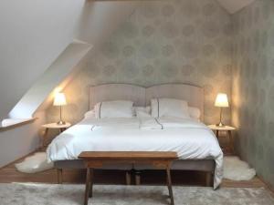 a bedroom with a white bed with two lamps at Gîte Beaune-la-Rolande, 3 pièces, 4 personnes - FR-1-590-114 in Beaune-la-Rolande