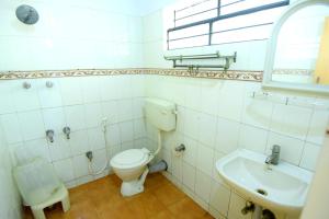 a bathroom with a toilet and a sink at Shastri Paradise opst to KSRTC Bus Stand in Mysore +13 photos