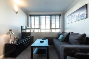 a living room with a couch and a table at BEST PRICE! - 1 MIN TO THE SHOPS, BARS, PUBS & RESTAURANTS! PERFECT LOCATION - FREE PARKING - FREE WIFI - SMART TV - COMFY BEDS - 4 Single beds or 2 Doubles in Portsmouth