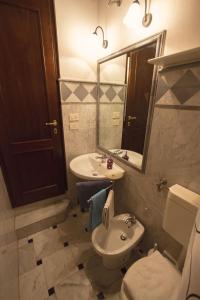 Un baño con lavabo, inodoro y espejo. en Apartment San Frediano, en Florencia