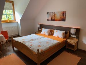 a bedroom with a large bed with orange sheets and pillows at Land- und Seminarpension Gamerith in Mottingeramt