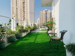 a balcony with green grass and chairs and buildings at Hotel City Premier in Gurgaon
