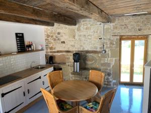 cocina con mesa de madera y sillas en Petit Chateau Melay, en Melay