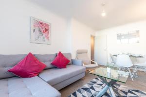 a living room with a gray couch with pink pillows at BEST PRICE!! - Contractor Heaven! 4 Singles beds or 2 King Size, Southsea Apartment- FREE PARKING, SMART TVS in Portsmouth