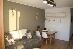 uma sala de estar com um sofá e uma mesa em Le Flocon-Studio cabine-Balcon 4-6 Pers à 100m des pistes em Chamrousse