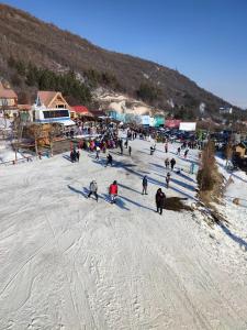 a group of people skiing down a snow covered slope at Guest House VELVET in Tsaghkadzor
