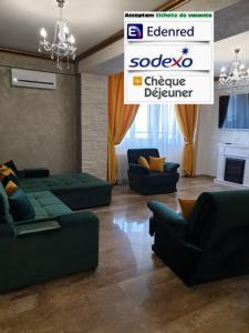 ein Wohnzimmer mit grünen Sofas und einem Kamin in der Unterkunft Monaco Summerland Apartments in Mamaia