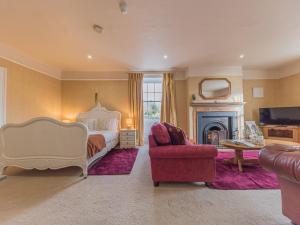 a large bedroom with a bed and a fireplace at Abbey Farm House in St Bees