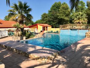 a swimming pool in a yard with trees and a house at Charming Mobile Home in Argels-sur-Mer with Stunning Beach Views in Argelès-sur-Mer +16 photos