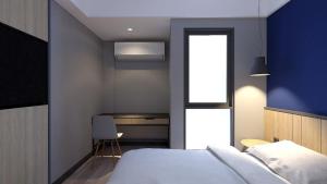 a bedroom with a bed and a blue wall at LeGreen Suite Sudirman in Jakarta