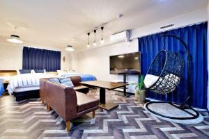 a hotel room with a bed and a living room at TOMMY CONDOMINIUM WAKASA 601 in Naha