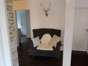 ein Wohnzimmer mit einem Stuhl und einem weißen Kissen in der Unterkunft Ferienwohnung Paradies Hella in Kippenheim