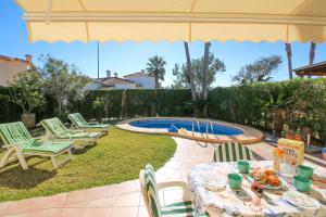 a patio with a table and chairs and a pool at Oliva Nova QL by CARLOSFERIEN in Oliva