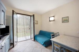 - un salon avec un canapé bleu et une fenêtre dans l'établissement Chico Agriturismo La Scuderia, à Molino Nuovo