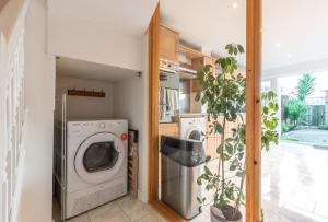 a laundry room with a washer and dryer and a plant at BEST PRICE! LARGE HOME FOR 4 - SMART TV - COMFY BEDS - GARDEN - 4 Single Beds or 2 Doubles! in Portsmouth