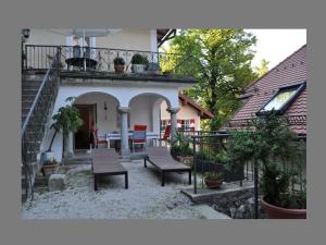 ein Haus mit einer Terrasse mit einem Tisch und Stühlen in der Unterkunft Ferienwohnungen Schlosseinkehr in Aschau im Chiemgau