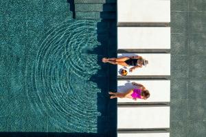 two women are standing next to a swimming pool at Sani Verde in Sani Beach