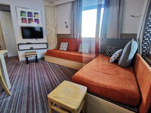 una camera d'albergo con due letti e una televisione di La Tania 309 Le Britania a Courchevel
