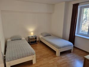 two beds in a room with a window at Pied à Terre Chaumont in Chaumont